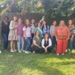 Las mujeres de Vision Sinai posan con alegría afuera de una casa, reunidas para celebrar el cumpleaños de una hermana—un hermoso momento de hermandad y conexión espiritual.