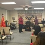 El pastor predica con pasión mientras Christopher traduce junto a él en el altar, compartiendo con poder espiritual el mensaje vibrante de Pentecostés