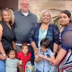 El pastor posa con alegría junto a sus dos hijas y tres nietos en la iglesia, representando un legado de fe y amor transmitido de generación en generación.