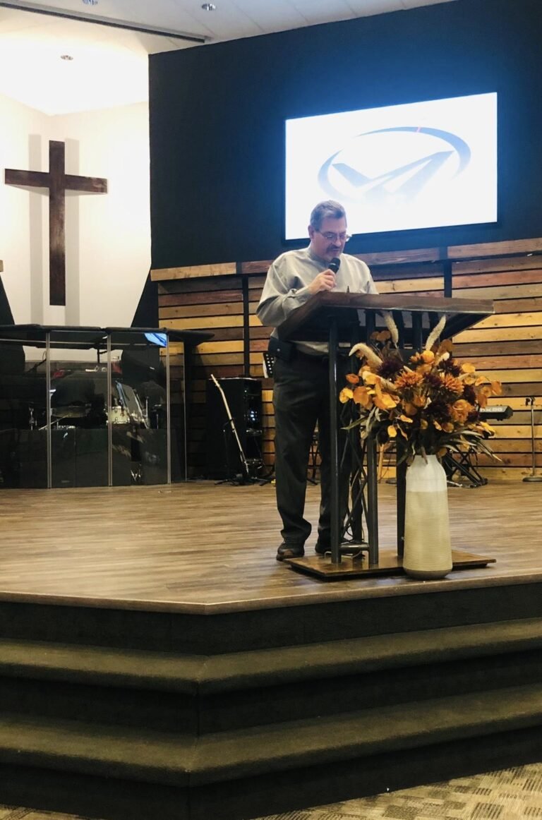 Director of Missions speaking at the front of the church during a service